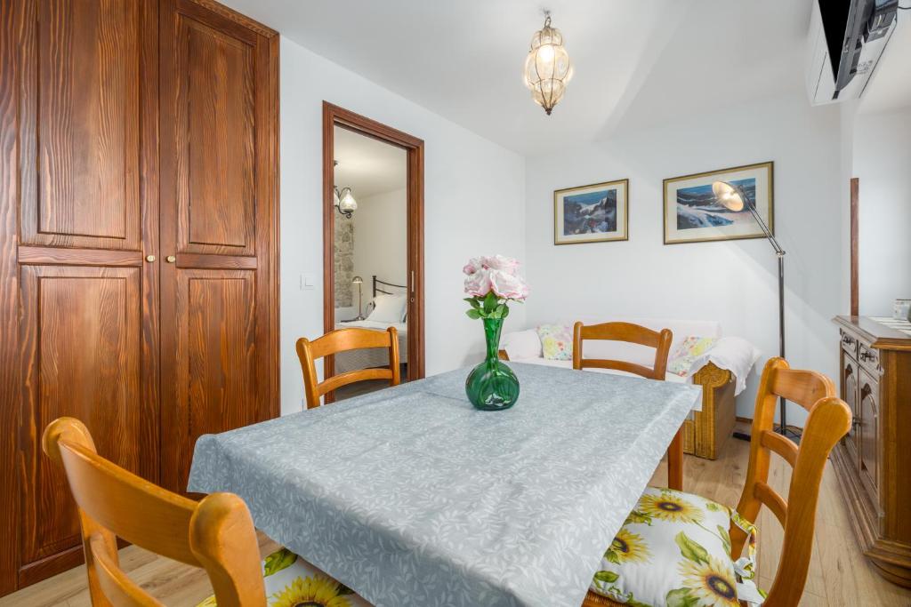 stół w jadalni z wazonem kwiatów na nim w obiekcie Apartment Lanterna Veneziana w Rovinj