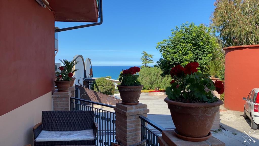 einen Balkon mit zwei großen Töpfen mit Blumen drauf in der Unterkunft VISTAMARE VILLAGE in Silvi Marina