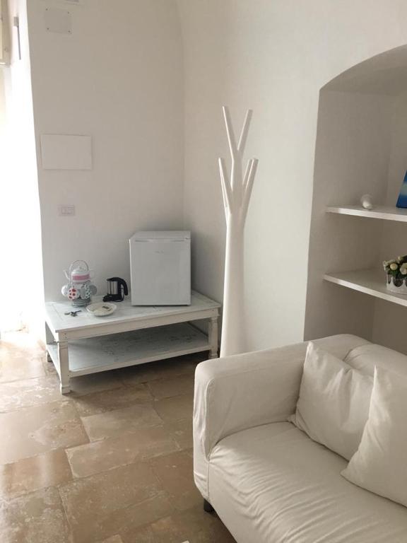 een woonkamer met een witte bank en een tafel bij B&B LEOPARDI in Gioia del Colle