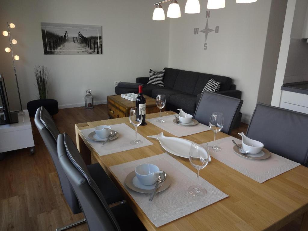 une salle à manger avec une table et des verres à vin dans l'établissement TER-101-Terrassenhuegel-Teilseeblick, à Scharbeutz