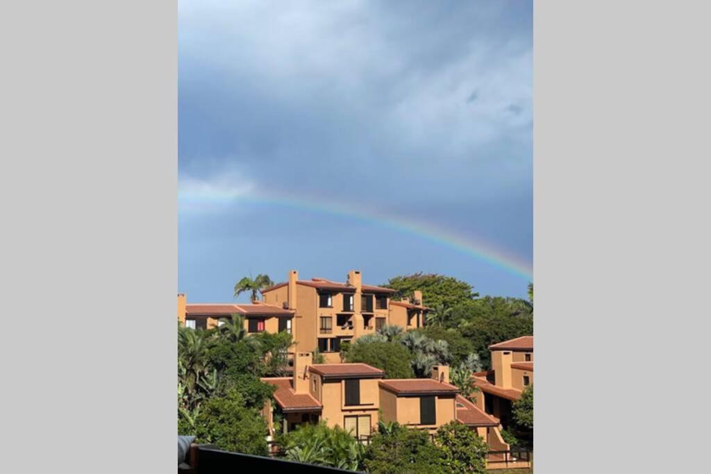 a group of houses with a rainbow in the sky at SAN LAMEER ESTATE - ViLLA 1921 LUXURY STUDIO in Southbroom