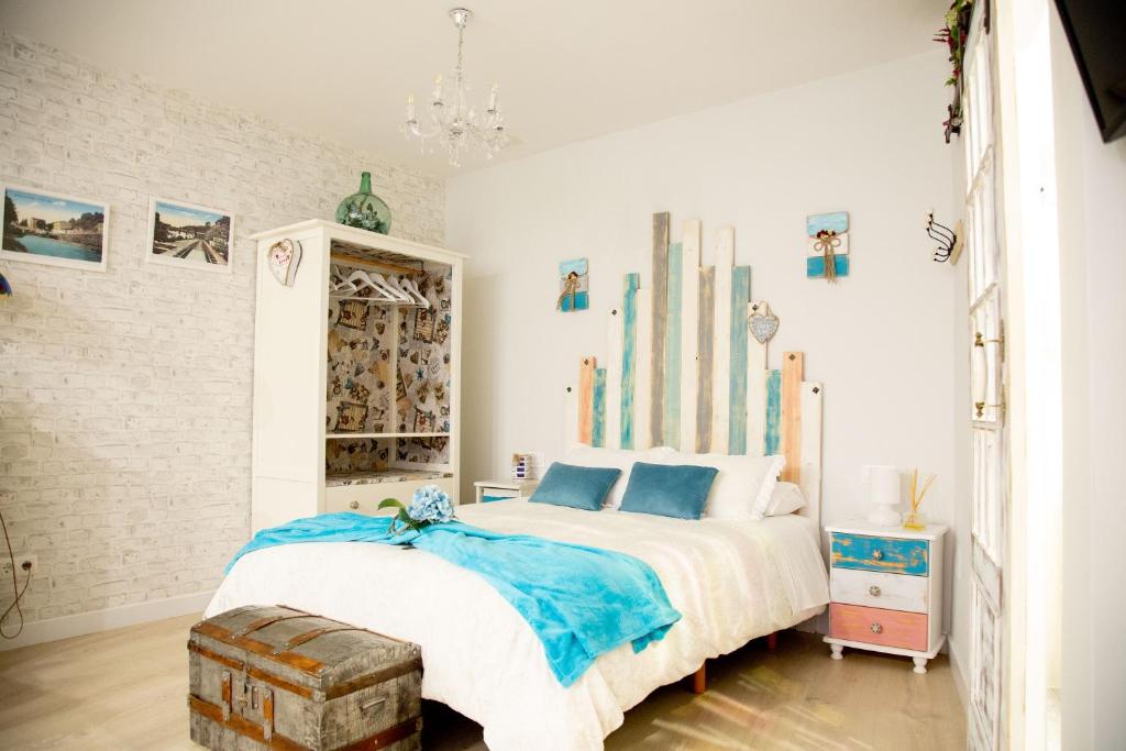 a bedroom with a large bed with blue pillows at Apartamentos Rincón de Cantarranas in Alhama de Aragón