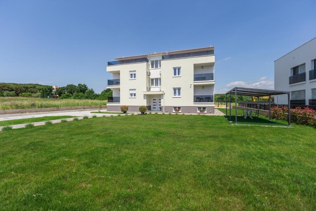 um grande quintal relvado em frente a um edifício em Villa Ancora em Rovinj