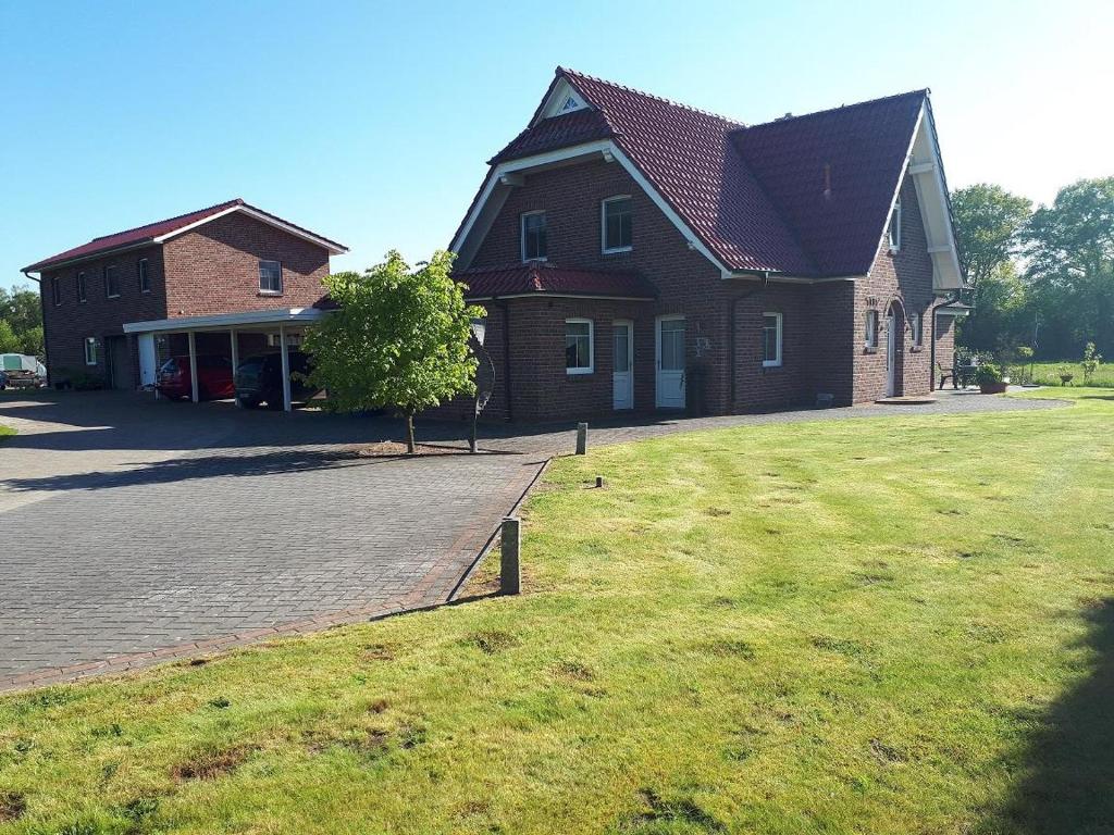 een huis met een grasveld ervoor bij Ferienwohnungen Pöttker in Bad Zwischenahn