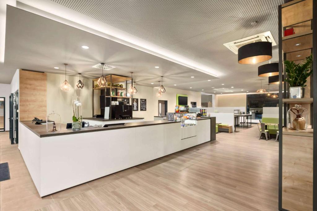 an office lobby with a white counter and tables at Super 8 by Wyndham Munich City North in Munich