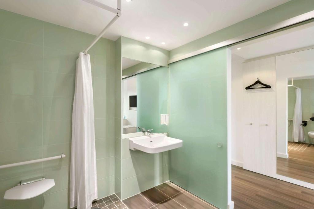a bathroom with a white sink and a mirror at Super 8 by Wyndham Munich City North in Munich