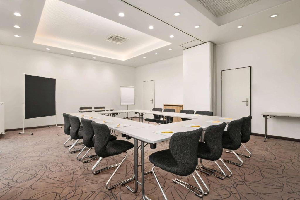 a conference room with a long table and chairs at Super 8 by Wyndham Munich City North in Munich