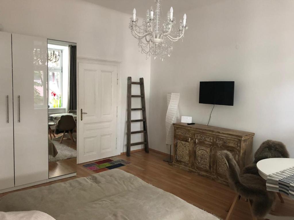 a living room with a chandelier and a television and a ladder at LieblingsPlatz in Vienna