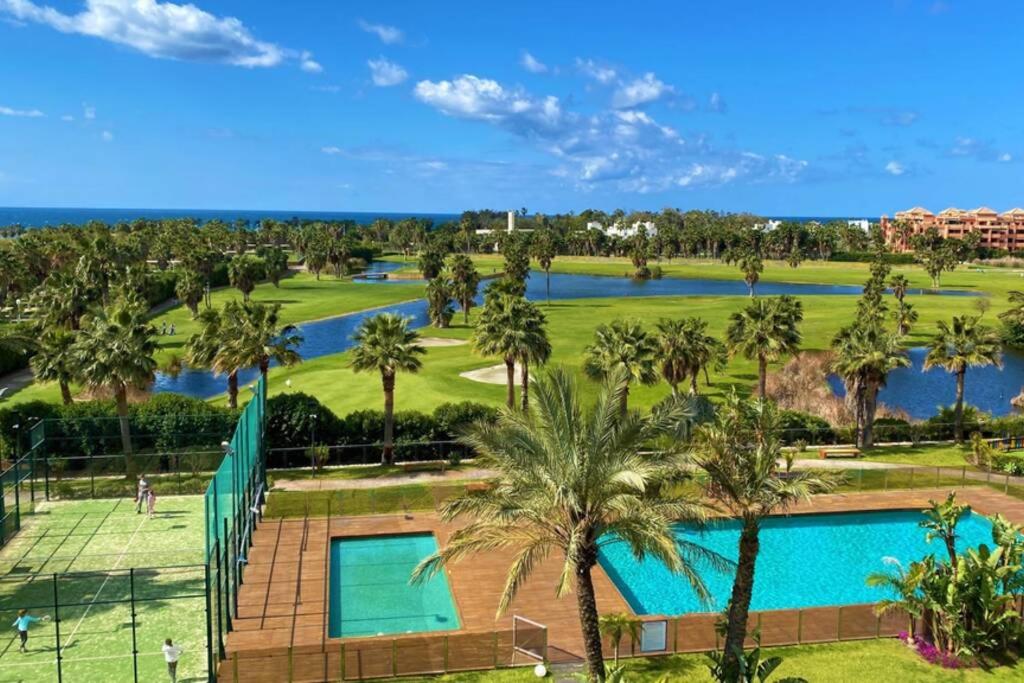 - une vue sur un parcours de golf avec une piscine et des palmiers dans l'établissement El Paraíso de Carmen, à Motril