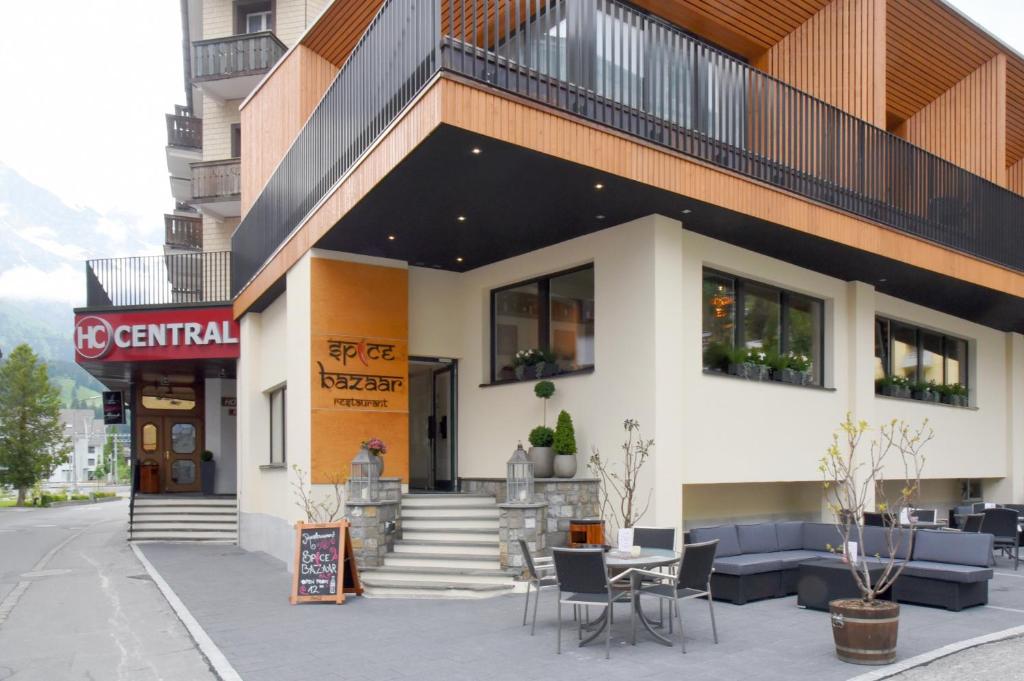 a building with chairs and a table in front of it at Hotel Central in Engelberg