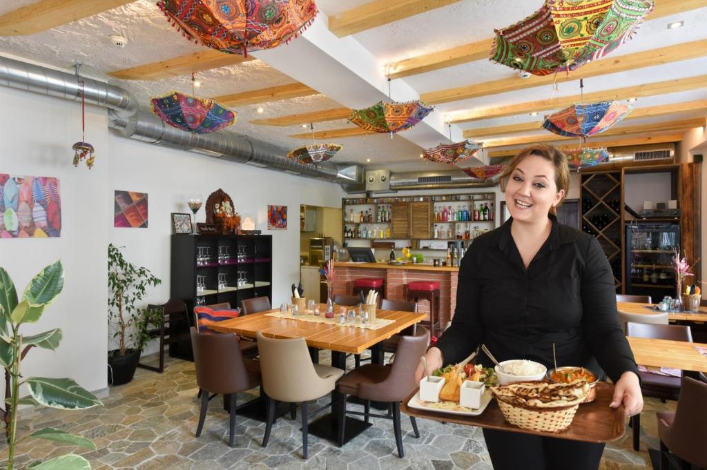 a woman standing in front of a table with food at Hotel Central in Engelberg