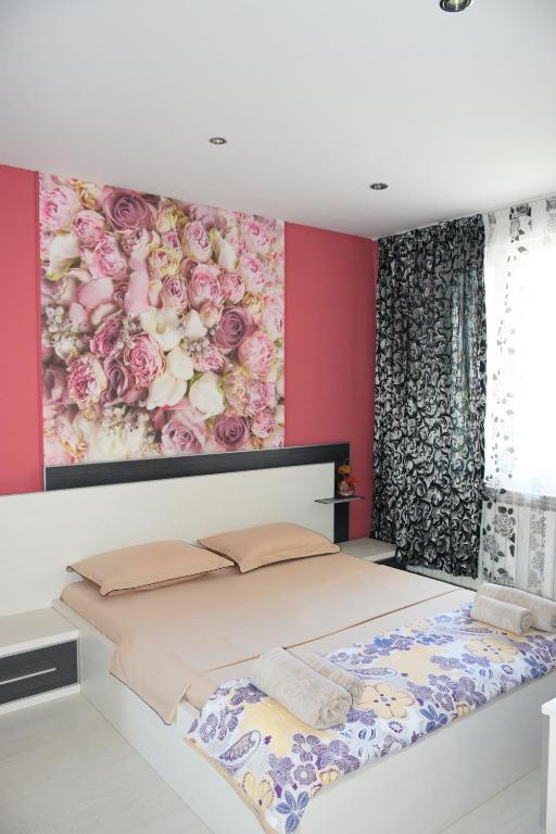 a bedroom with a bed with a flower painting on the wall at dream apartment in Obzor