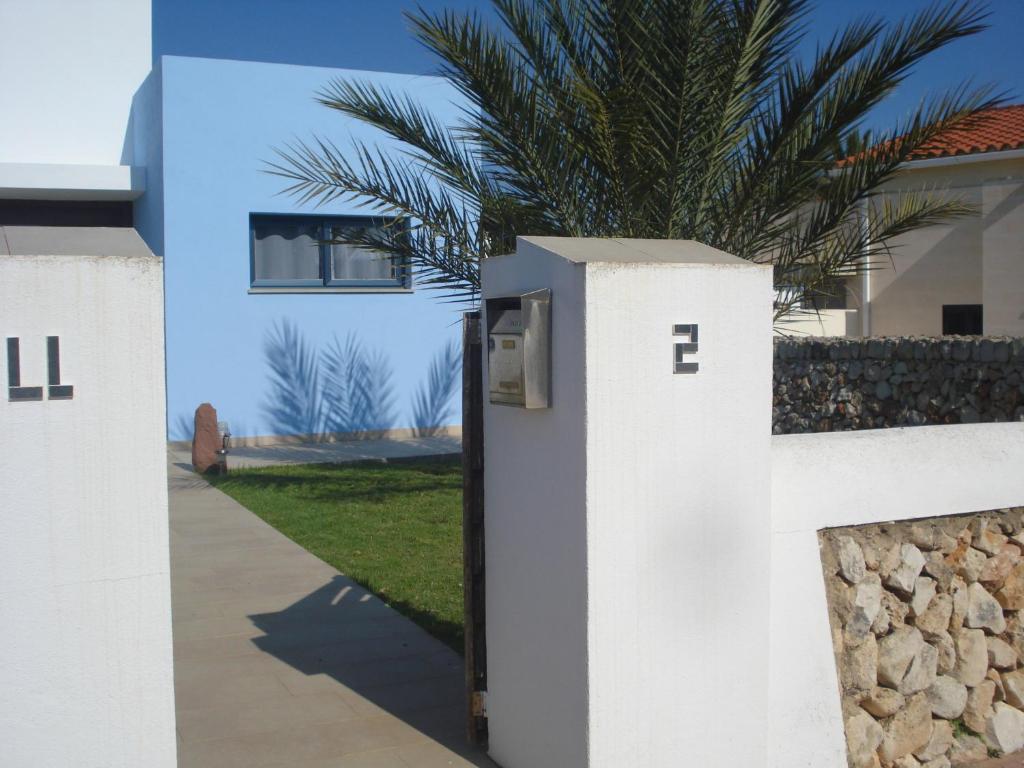 eine weiße Wand mit einem Briefkasten vor einem Haus in der Unterkunft Villa Romaní SUITE in Son Carrio