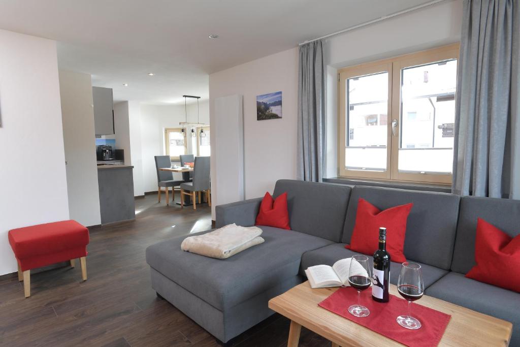 a living room with a blue couch and red pillows at Ferienwohnungen Brigitte in Oberstdorf