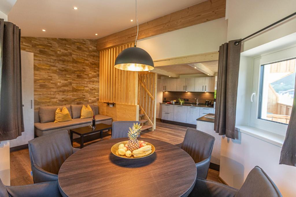 uma sala de jantar e sala de estar com mesa e cadeiras em Tevini Boutique Suites by we rent em Zell am See