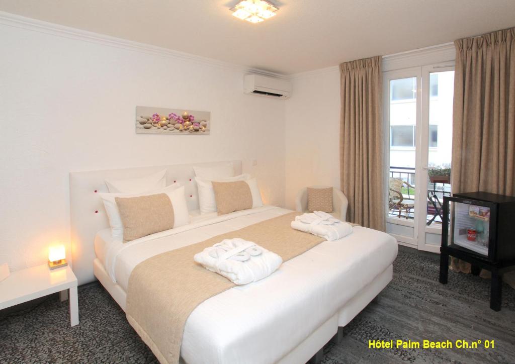 カンヌにあるHOTEL PALM BEACHのベッドルーム1室(ベッド1台、タオル2枚付)