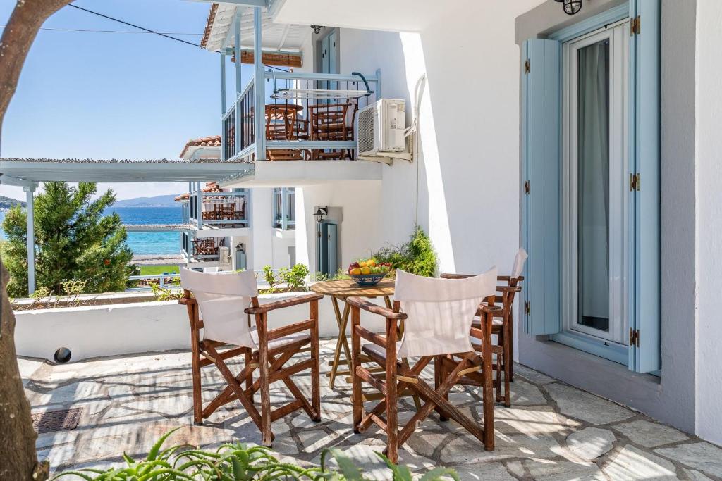 a table and chairs on a balcony with a view of the ocean at Milia Beach Apartments in Paralia Milia