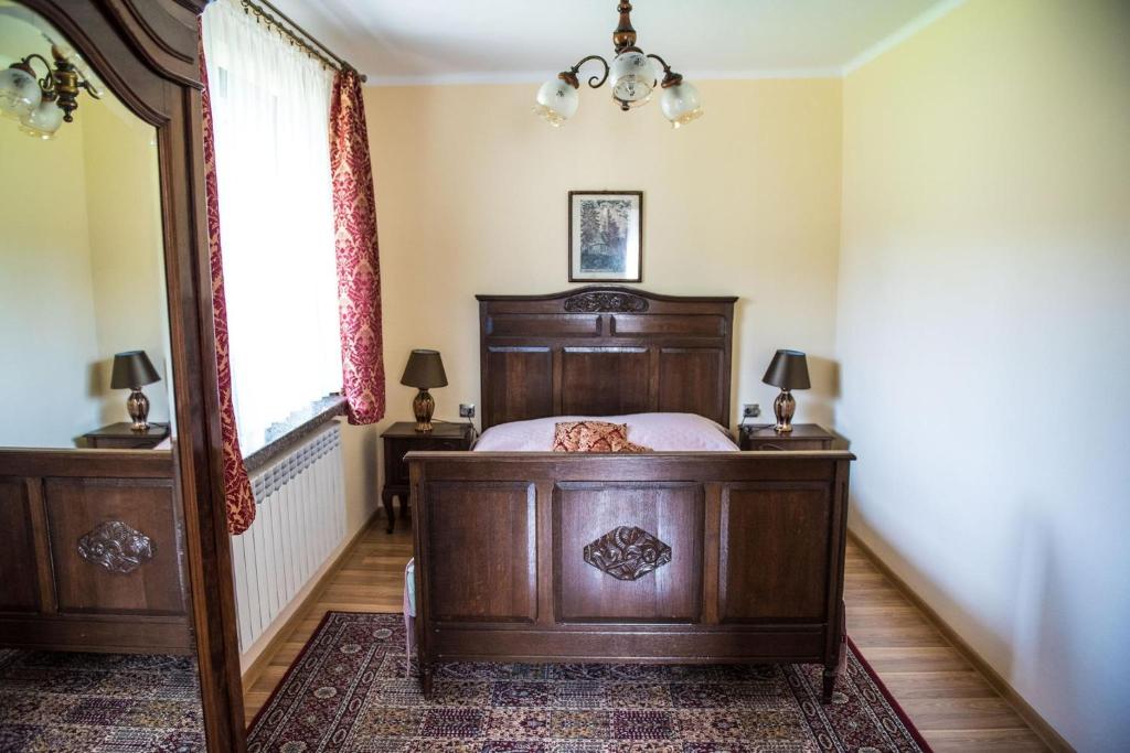 a bedroom with a wooden bed and a window at Noclegi u Ewy in Witów