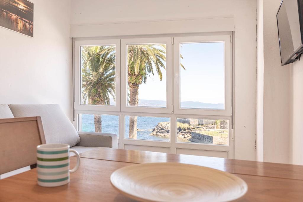 Un comedor con mesa y vista al mar. en Apartamento Fisterra con vistas al mar, en Finisterre