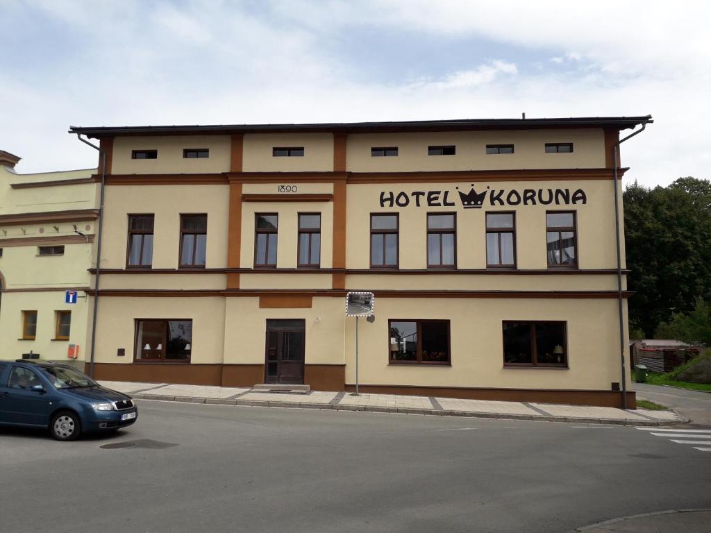 a building with a car parked in front of it at Hotel Koruna penzion in Teplice nad Metují