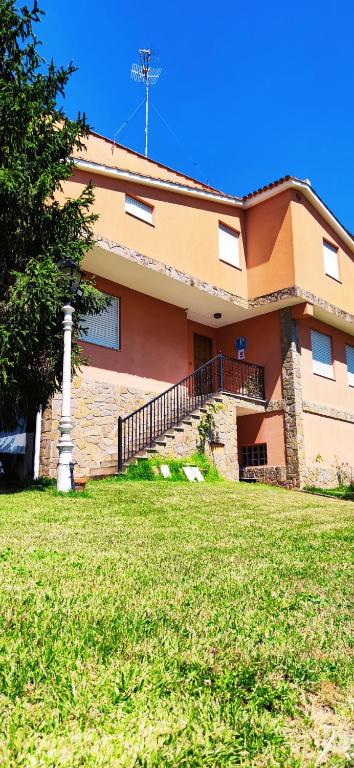 a building with a grass field in front of it at Pensión Nigrán in Nigrán