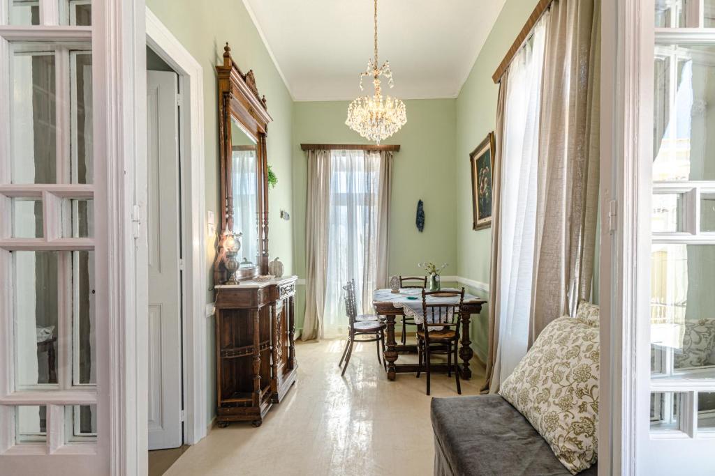 Neoclassical Mansion in Andros Town في آنذروس: غرفة معيشة مع طاولة وغرفة طعام