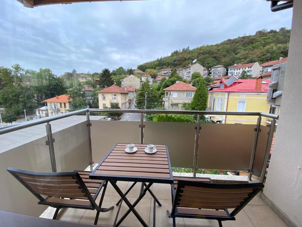 a table and two chairs on a balcony with a view at Coziness and comfort in the Old Town in Veliko Tŭrnovo