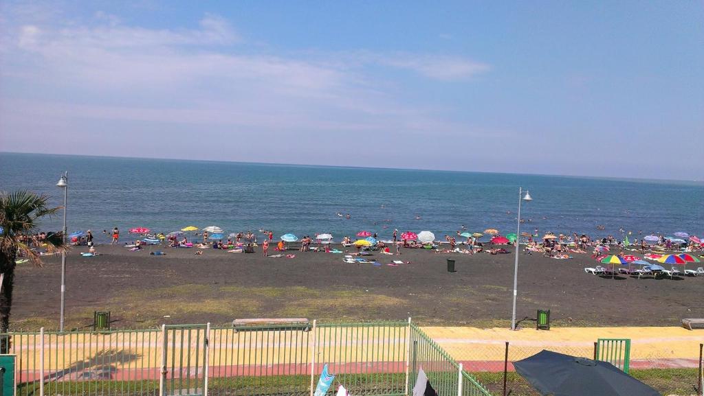 a group of people on a beach with umbrellas at Ureki House in Ureki