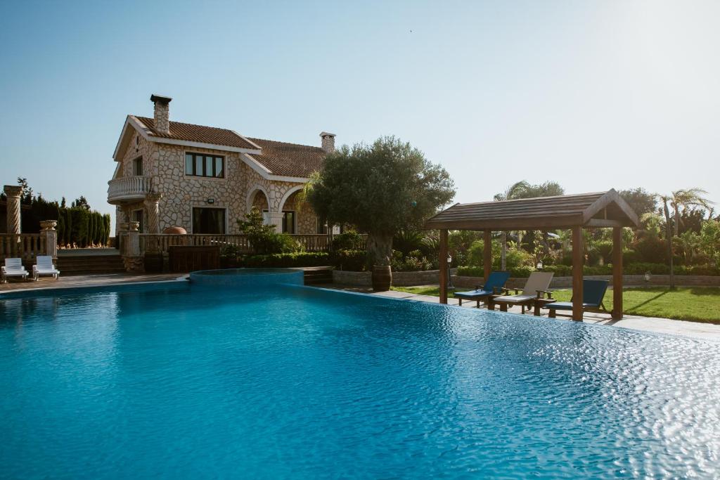 a swimming pool in front of a house at Grand Mansion Countryhouse & Spa in Phrenaros
