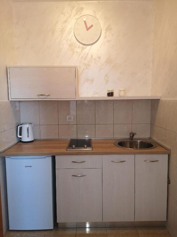 una cocina con fregadero y un reloj en la pared en Clock Tower Apartments, en Podgorica