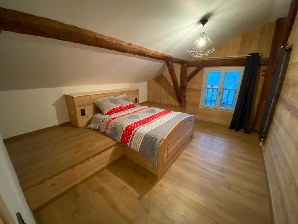 - une chambre avec un lit dans un dortoir doté de parquet dans l'établissement Appartement 75m2 duplex au cœur du village de Queige, à Queige