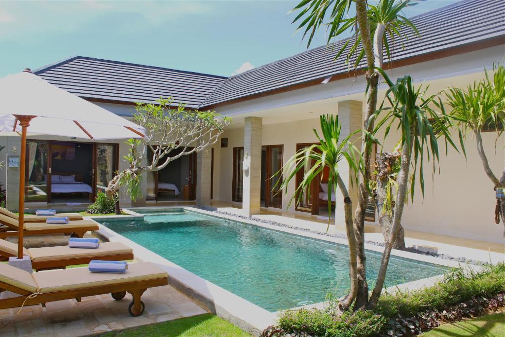 a villa with a swimming pool and a resort at The Daun Bali in Canggu