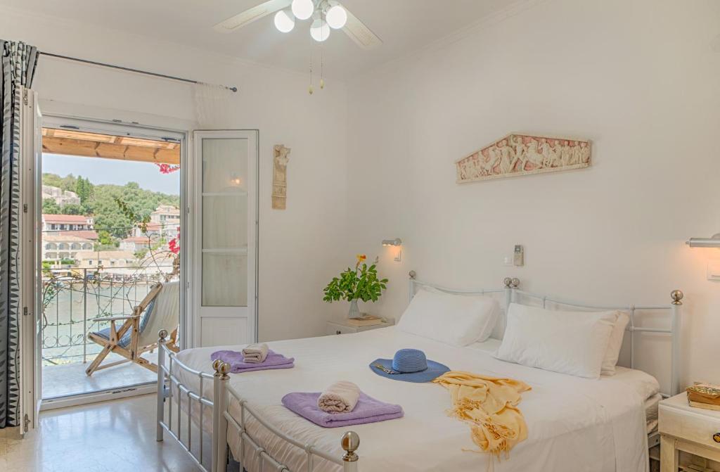 una camera da letto con un letto con asciugamani e un balcone di MANESSIS Apartments Kassiopi Bay Corfu a Kassiopi