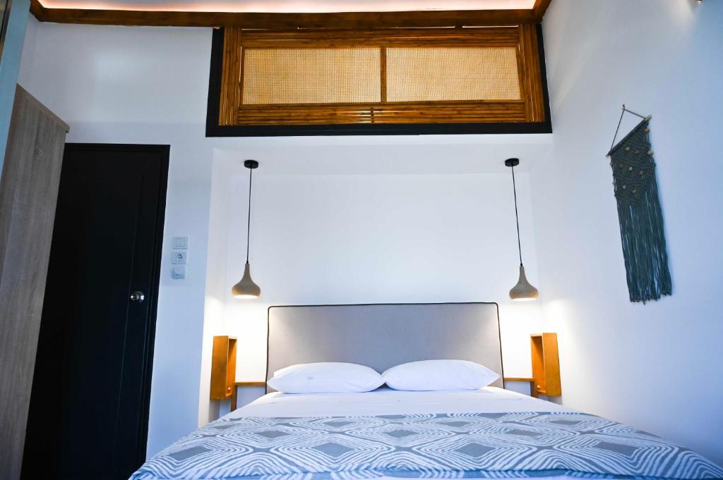 ein Schlafzimmer mit einem Bett mit zwei Kissen und einem Fenster in der Unterkunft Elia’s Guest House in Koríni