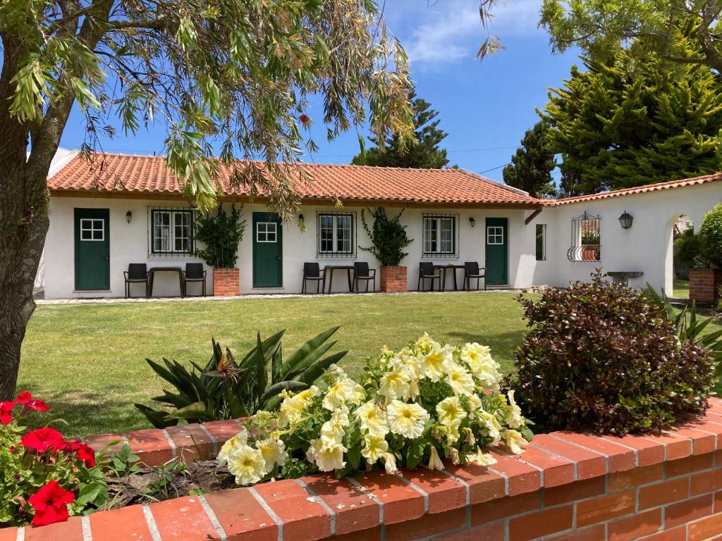 uma casa com uma parede de tijolos e flores em Apartamentos Vale Da Varzea em Areia Branca