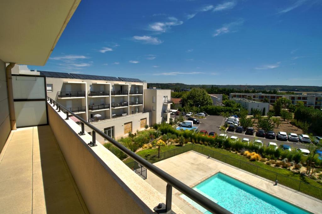 - un balcon avec vue sur le parking dans l'établissement KOSY Appart'Hôtels - Campus Del Sol Esplanade, à Montfavet