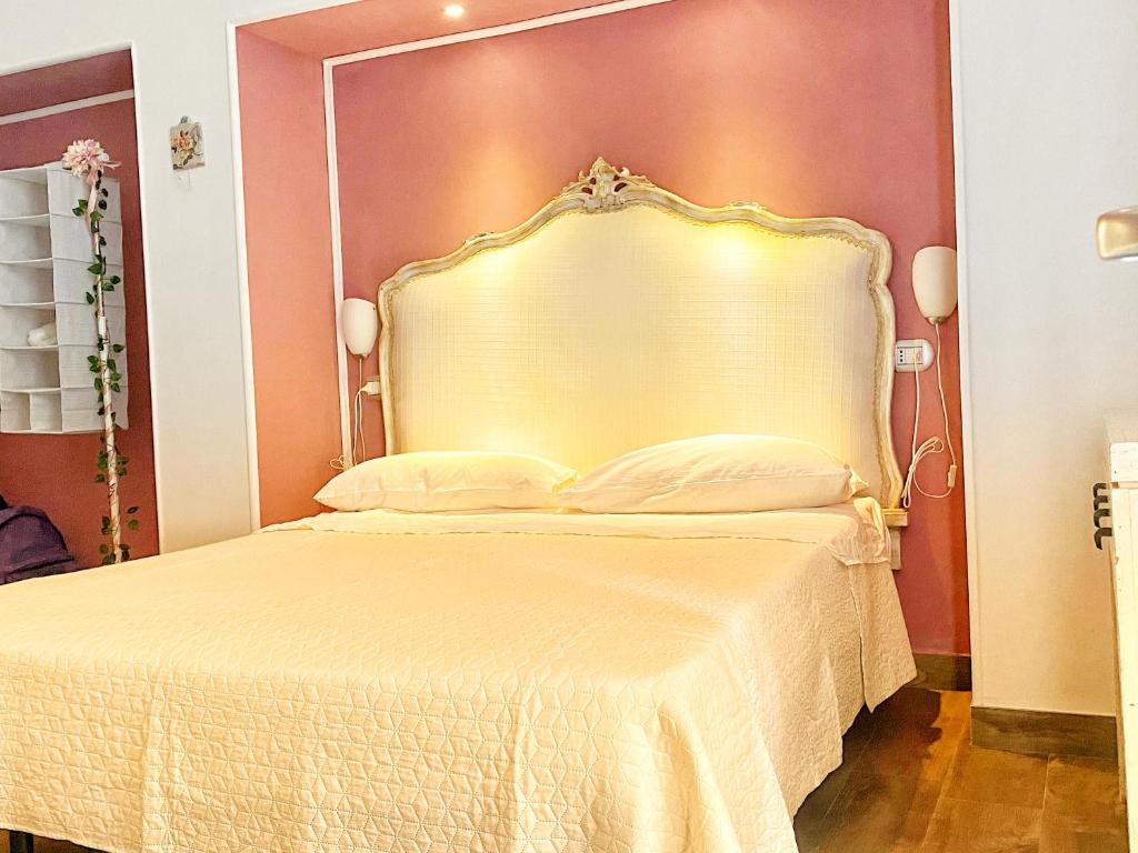ナポリにあるB&B Central Station Suiteのベッドルーム1室(大型ベッド1台、金のヘッドボード付)