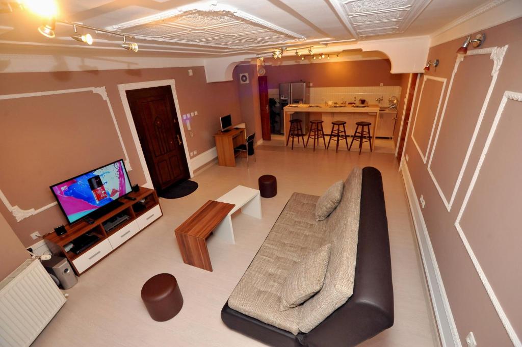 uma sala de estar com um sofá e uma televisão em Hostel Day 'N' Night em Niš