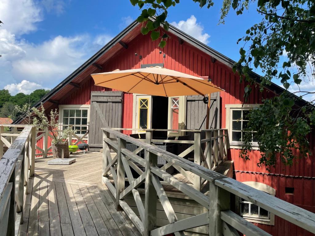 a red barn with an umbrella on a deck at Arphus Lodge in Eskilstuna