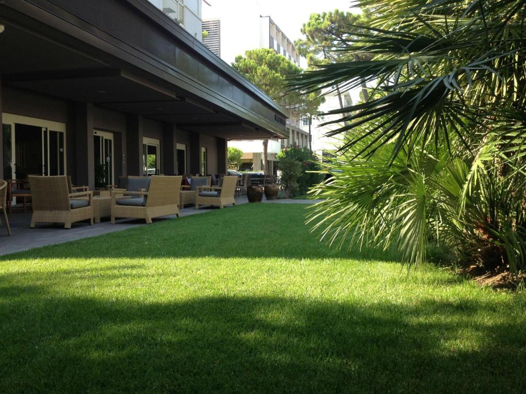 un prato verde con sedie e un edificio di Hotel Parco a Milano Marittima