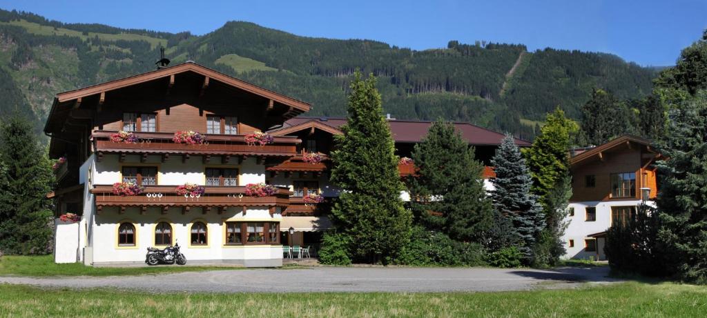 a large building with flowers on the balcony at Pension Alpenrose in Maishofen