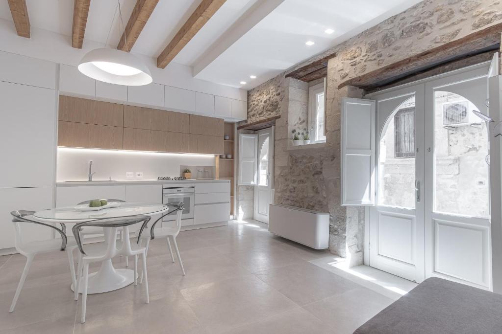 a kitchen with a table and chairs in a room at Casa Zummo Ortigia Luxury Apartment in Siracusa