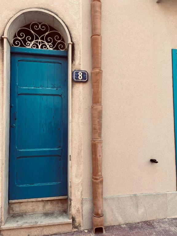 una puerta azul en el lateral de un edificio en Sulle ali del Mediterraneo, en Marettimo