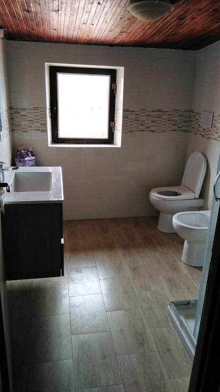 a bathroom with a sink and a toilet and a window at Andi in Stalettì