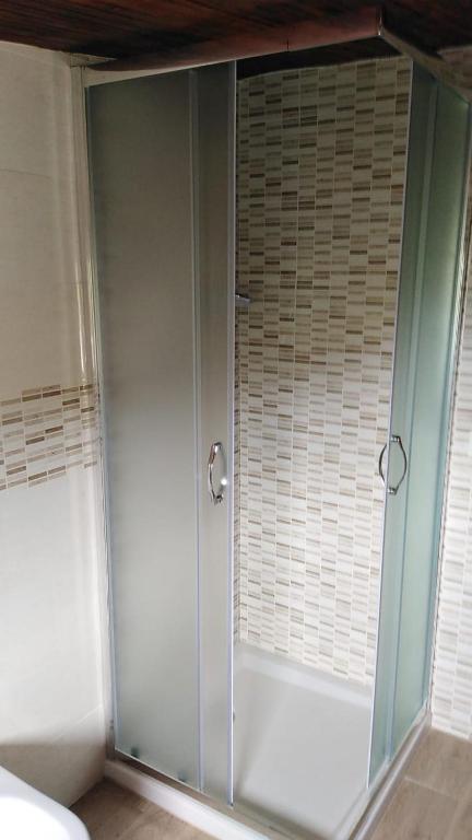 a glass shower in a room with a window at Andi in Stalettì
