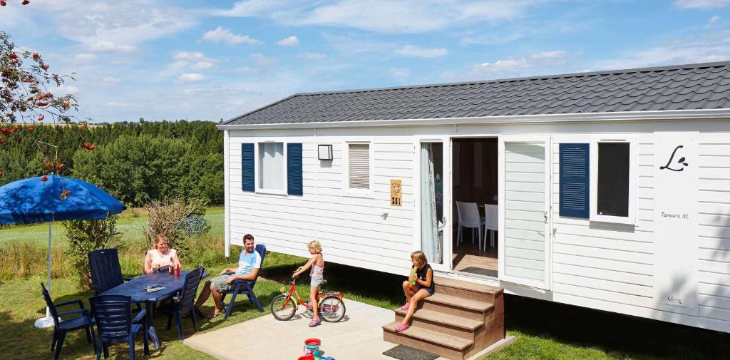 un groupe d'enfants jouant à l'extérieur d'une petite maison dans l'établissement Chênefleur, à Tintigny