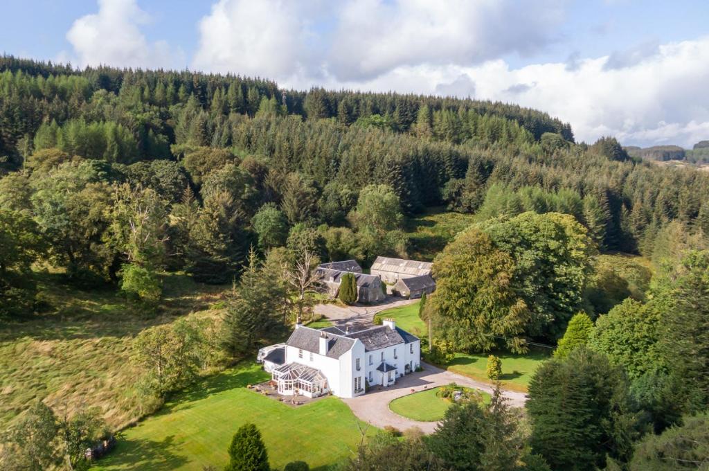 an aerial view of a house in the middle of a forest at Killean Farmhouse B&B in Inveraray