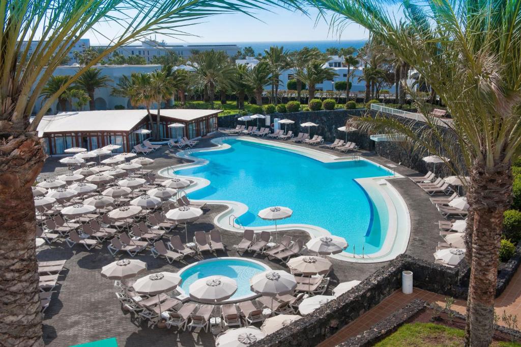 una vista aérea de una piscina del complejo con sombrillas y sillas en Relaxia Olivina, en Puerto del Carmen