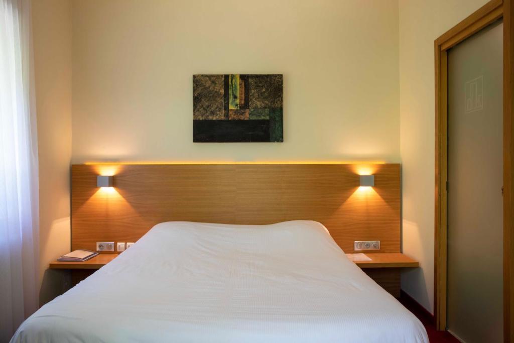 Postel nebo postele na pokoji v ubytování Hôtel Restaurant Logis Auberge Sundgovienne