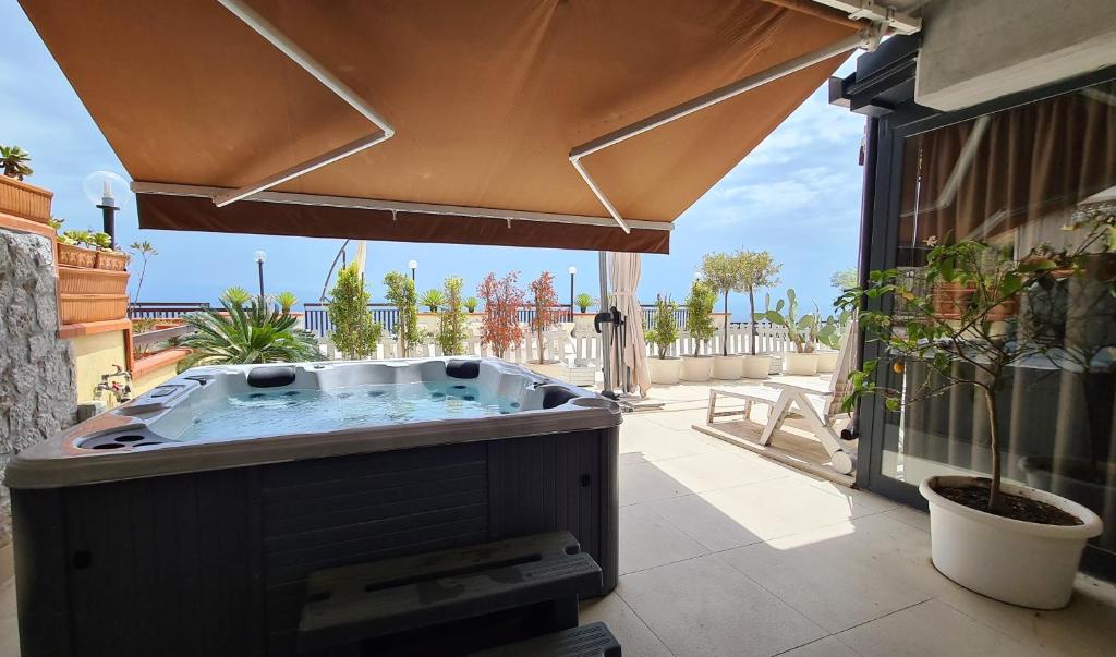 uma banheira de hidromassagem no pátio de uma casa em Maison de Charme Taormina with private jacuzzi em Taormina